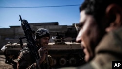 An Iraqi soldier carries a machine gun while heading to the front line in Mosul, Iraq, Dec. 6, 2016. IS commanders have “been adapting all along,” changing tactics to keep Iraqi forces off-balance as the latter push further into Mosul, a U.S. official said.