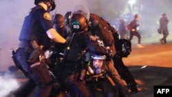 Empat petugas polisi Portland menangkap seorang pengunjuk rasa di dekat Mississippi Avenue pada 14 Agustus 2020 di Portland, Oregon. (Foto: AFP)