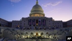 FILE - The sun rises behind the U.S. Capitol in Washington, Jan. 12, 2025. Because temperatures are expected to dip below freezing on Monday, President-elect Donald Trump is moving his swearing-in ceremony from outside to inside the U.S. Capitol.