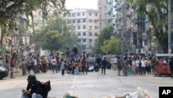 Los manifestantes ocupan una calle en Rangún, Myanmar, donde han muerto decenas de personas que protestaban contra el golpe militar del 1 de febrero de 2021.