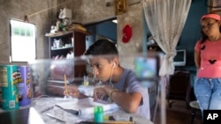 Samuel Andrés Mendoza mira una imagen de un Pokémon en su computadora antes de dibujarlo, en su casa en Barquisimeto, Venezuela. Marzo 2, 2021. Foto: AP.
