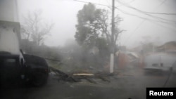Kerusakan dan jalan-jalan yang tergenang air terlihat di area yang terkena hantaman Badai Maria di Guayama, Puerto Rico, 20 September 2017.
