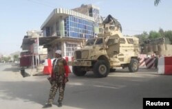 An Afghan security force personnel stands guard at the entrance gate of the government compound of Farah province, western Afghanistan, May 15, 2018.