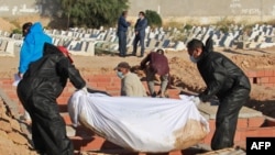 ARCHIVES - Des fossoyeurs dans un cimetière près de la ville côtière de Sfax, portent des tenues de protection lors de l'enterrement de l'un des 52 migrants africains, décédé en mer lorsque leur bateau a chaviré près des îles Kerkennah en Tunisie, le 15 juin 2020.