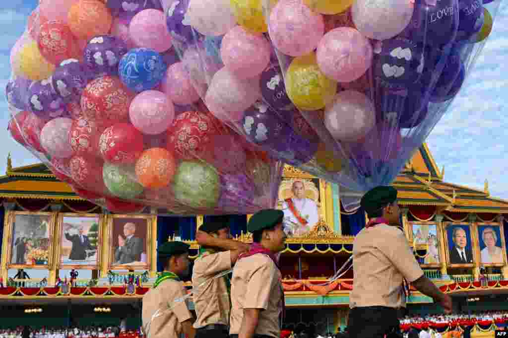 Scouts carry balloons during the 20th anniversary of Cambodian King Norodom Sihamoni's coronation in front of the Royal Palace in Phnom Penh.