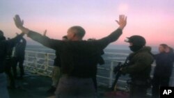 In this image provided by Greenpeace, Oct. 2, 2013, Russian Coast Guards seize the Greenpeace ship the Arctic Sunrise and detain the crew following a protest by Greenpeace activists at a Russian oil platform in the Pechora Sea, off the coast of Russia, Sept. 19, 2013. 