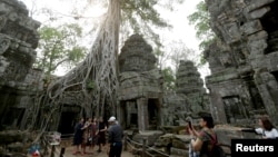 FILE - Tourists visit the Ta Prohm temple complex in Siem Reap province, Cambodia, on March 16, 2019.