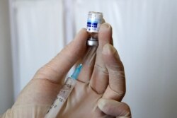 A handout picture provided by the Iranian presidency on Aug. 8, 2021, show a medic preparing a dose of the domestically-produced coronavirus vaccine 'COVIran Barekat' in Tehran.