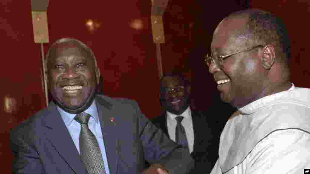 Le président de la Côte d'Ivoire Laurent Gbagbo, à gauche, sourit lors d'une rencontre avec Mgr Jean Pierre Koutouan, à droite, venu le féliciter dans la ville d'Abidjan, Côte d'Ivoire, 10 décembre 2010.