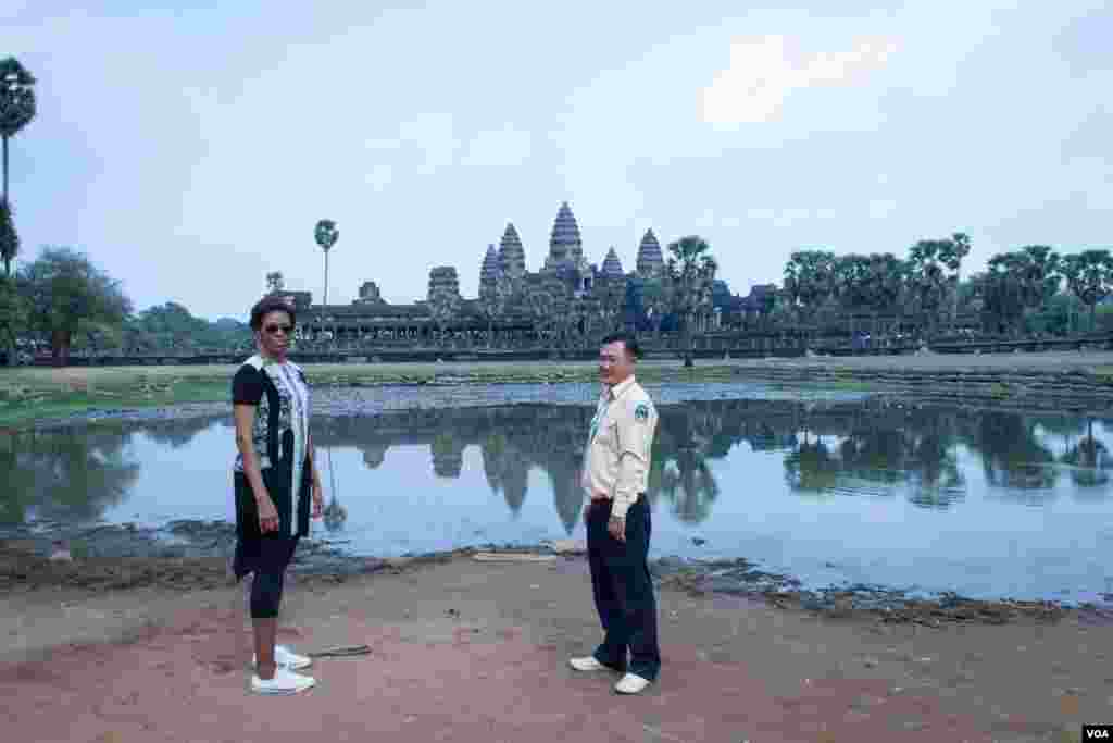 មគ្គុទ្ទេសក៍ទេសចរណ៍បង្ហាញដល់លោកស្រី Michelle Obama ក្នុងពេលដើរទស្សនានៅបរិវេណប្រាសាទអង្គរវត្ត នៅរសៀលថ្ងៃសៅរ៍ទី២១ ខែមីនា ឆ្នាំ២០១៥។ (នៅ វណ្ណារិន/VOA)