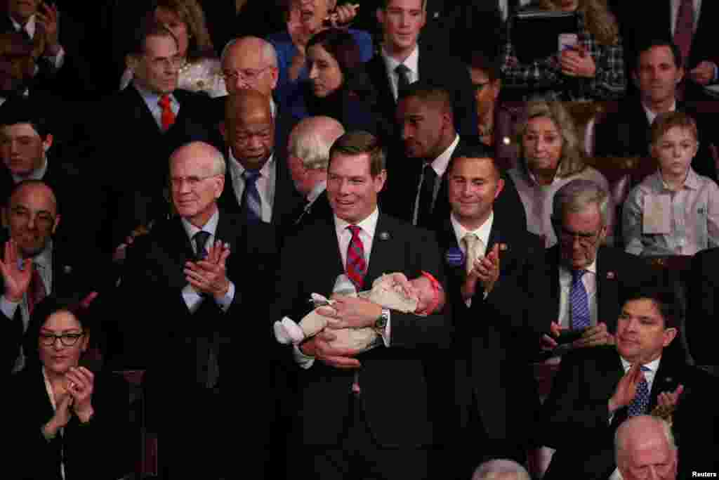 U.S. Rep. Eric Swalwell (D-CA) holds his daughter Kathryn as the U.S. House of Representatives meets for the start of the 116th Congress inside the House Chamber on Capitol Hill in Washington, Jan. 3, 2019.