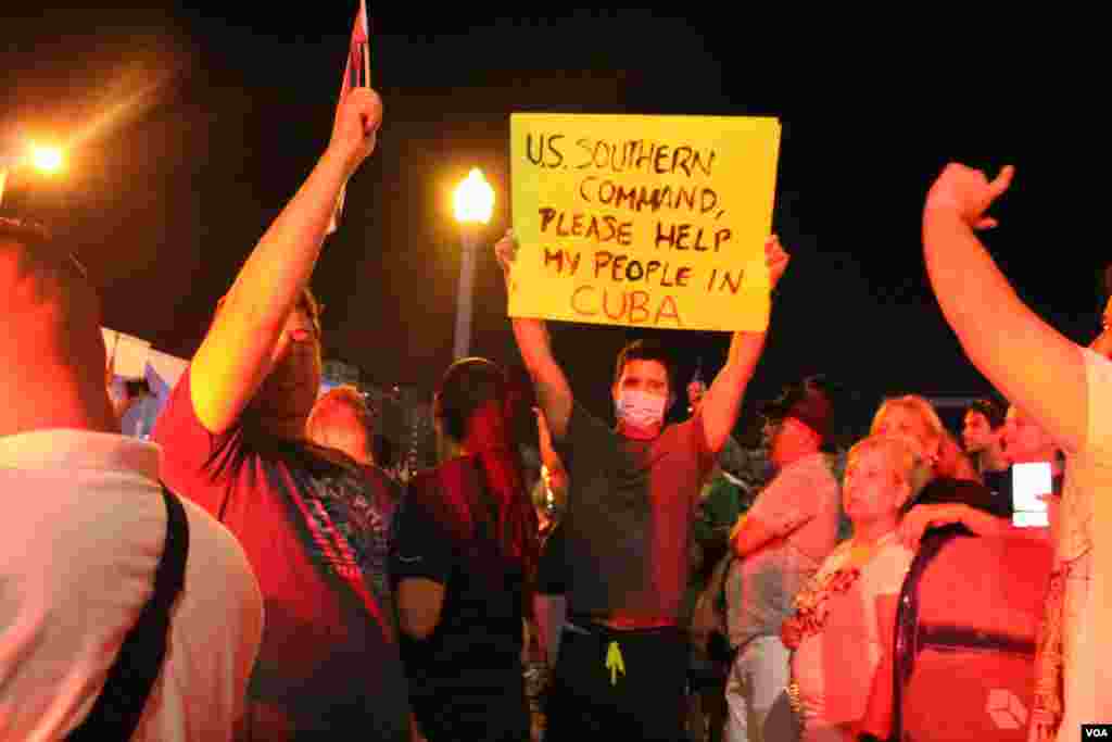 Un joven en la Calle 8 de Miami, Florida, por medio de un cartel pide la intervención del Ejército de Estados Unidos "en apoyo al pueblo de Cuba" tras las protestas sucedidas en la isla el domingo 11 de julio de 2021. Foto: Luis F. Rojas, VOA.