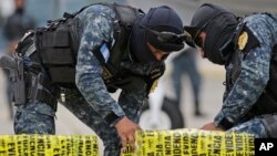 ARCHIVO - Paquetes de cocaína incautados por la policía guatemalteca se descargan en una base de la fuerza aérea en la ciudad de Guatemala, el lunes 20 de mayo de 2019. El país centroamericano es una importante ruta para el narcotráfico.