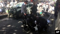 In this image taken from video made available by Lachlan V, a man is held by police after a car was driven into pedestrians on a busy Melbourne intersection in Melbourne, Australia Thursday Dec. 21, 2017. 