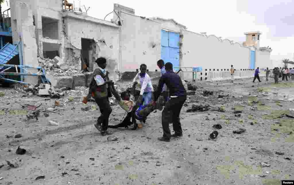 Somali government soldiers evacuate an injured man after a suicide bomb attack at a U.N. compound in Mogadishu, June 19, 2013.