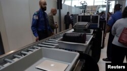 Bagasi dan laptop penumpang diperiksa melalui alat pemindai di bandara JFK, New York (foto: ilustrasi). 