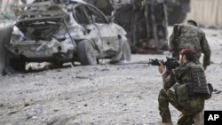 An Afghan soldier secures the scene of a suicide attack at the gate of an airport in Jalalabad, Nangarhar province east of Kabul, Afghanistan, Feb. 27, 2012.