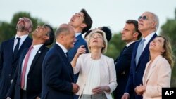 De derecha a izquierda, la primera ministra italiana, Giorgia Meloni, el presidente de EEUU, Joe Biden, observan junto a otros mandatarios del G7 una demostración de paracaidismo durante la cumbre de líderes en Borgo Egnazia, Italia, el 13 de junio de 2024.