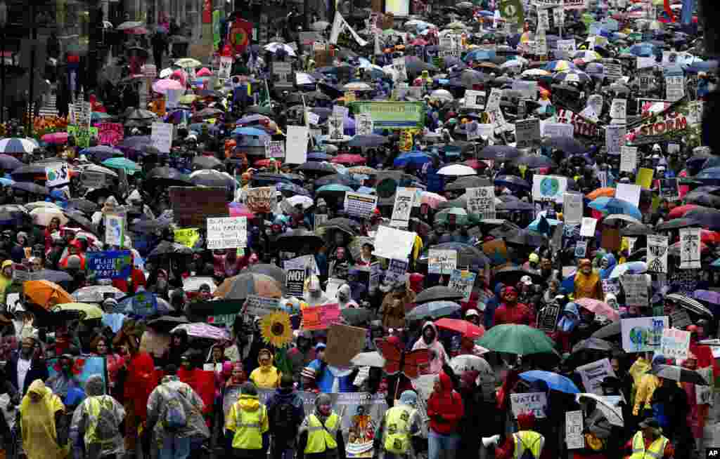 Demonstrators march on the State Street during "100 Days of Failure" protest and march in Chicago, April 29, 2016. Thousands of people across the U.S. are marking President Donald Trump's hundredth day in office by marching in protest of his environmental policies.