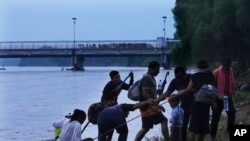 Migrantes venezolanos llegan al lado mexicano de la frontera después de navegar en balsa por el río Suchiate, la frontera entre Guatemala y México, cerca de Ciudad Hidalgo, estado de Chiapas, México, el martes 4 de octubre de 2022. (Foto AP/Marco Ugarte)