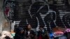 ARCHIVO - Migrantes venezolanos esperan ayuda frente a la Comisión Mexicana de Ayuda a Refugiados en la Ciudad de México, en octubre de 2019.