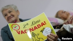 Una anciana brasileña muestra un letrero de Vacunada! tras recibir la segunda dosis de la vacuna china CoronaVac contra COVID-19 en Sao Paulo, Brasil, el 26 de febrero de 2021.