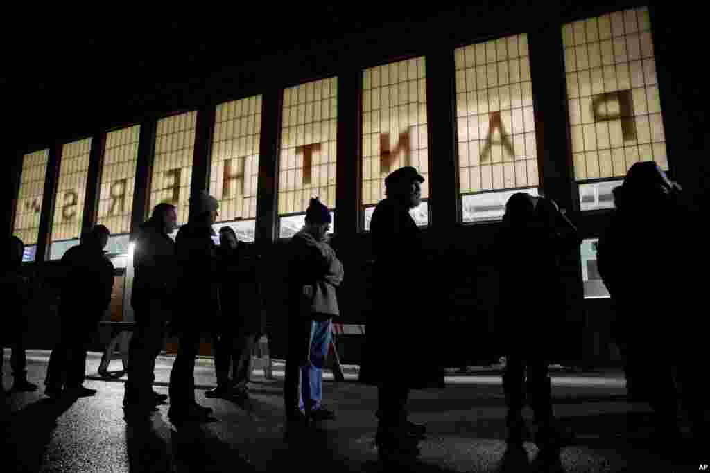 New Hampshire primary voters wait for their voting precinct to open outside Parker-Varney Elementary School, Tuesday, Feb. 11, 2020, in Manchester, N.H.