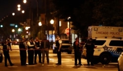 Police officers investigate at the scene of a shooting outside a funeral home in Chicago, Illinois, July 21, 2020.