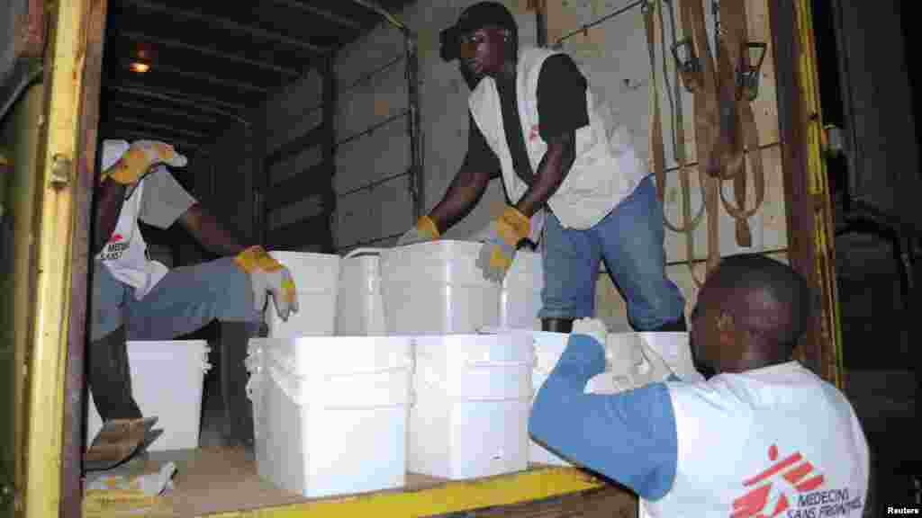 Des travailleurs de l'ONG internationale Médécins Sans Frontières font du porte-à-porte, distribuant des trousses du désinfectant pour prévenir Ebola à Monrovia, Liberia, le 20 octobre 2014.