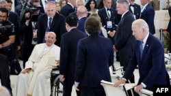 Perdana Menteri Jepang Fumio Kishida (tengah) dan Presiden Argentina Javier Milei antre untuk menyapa Paus Fransiskus di tengah sesi diskusi tentang kecerdasan buatan (AI) di KTT G7 di resor Borgo Egnazia, di Savelletri, Italia, Jumat, 14 Juni 2024. (Foto: Ludovic Marin/AFP)