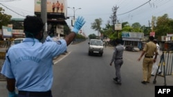 ប៉ូលិស​ និង​អ្នក​ស្ម័គ្រ​ចិត្ត​បញ្ឈប់​រថយន្ត​មួយ​នៅ​កន្លែង​ត្រួតពិនិត្យ​ ក្នុង​ពេល​បិទ​ប្រទេស​ដើម្បី​ទប់ទល់​ការ​រីករាលដាល​នៃ​មេរោគ​កូរ៉ូណា នៅ​ក្នុង​ក្រុង Siliguri កាលពី​ថ្ងៃទី១៣ ខែមេសា ឆ្នាំ២០២០។