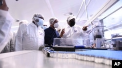 Le président sud-africain Cyril Ramaphosa, à droite, visite les installations d'ASPEN Pharmaceuticals à Port Elizabeth, en Afrique du Sud, lundi 29 mars 2021.