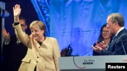 German Chancellor Angela Merkel waves next to Christian Democratic Union (CDU) leader and top candidate for chancellor Armin Laschet during his election rally in Stralsund, Germany, Sept. 21, 2021. 