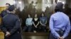 Feminist punk group Pussy Riot members, from left, Yekaterina Samutsevich, Maria Alekhina and Nadezhda Tolokonnikova sit in a glass cage at a courtroom in Moscow, Russia, Aug 17, 2012.