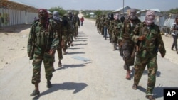 FILE - Members of Somalia's al-Shabab militant group patrol on the outskirts of Mogadishu, Somalia, March 5, 2012. 
