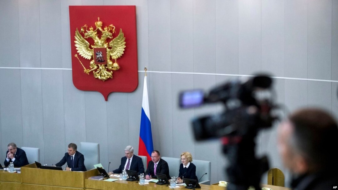 FILE - A video journalist shoots from the balcony as Russian lawmakers prepare to vote in the State Duma, the Lower House of the Russian Parliament in Moscow, Russia, Dec. 6, 2017. 