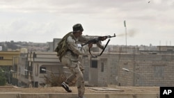 A Libyan revolutionary fighter fires his machine gun while attacking pro-Gadhafi forces on the western side of Sirte, Libya, October 13, 2011.
