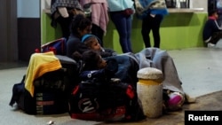 Venezuelan migrants rest with their luggage as they wait to register their entry into Ecuador, at the Rumichaca International Bridge, Ecuador, Aug. 9, 2018.