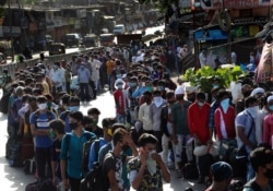 Migrant workers line up to board buses for their onward journey by train to their home states, at Dharavi, one of Asia's largest slums, in Mumbai, India.