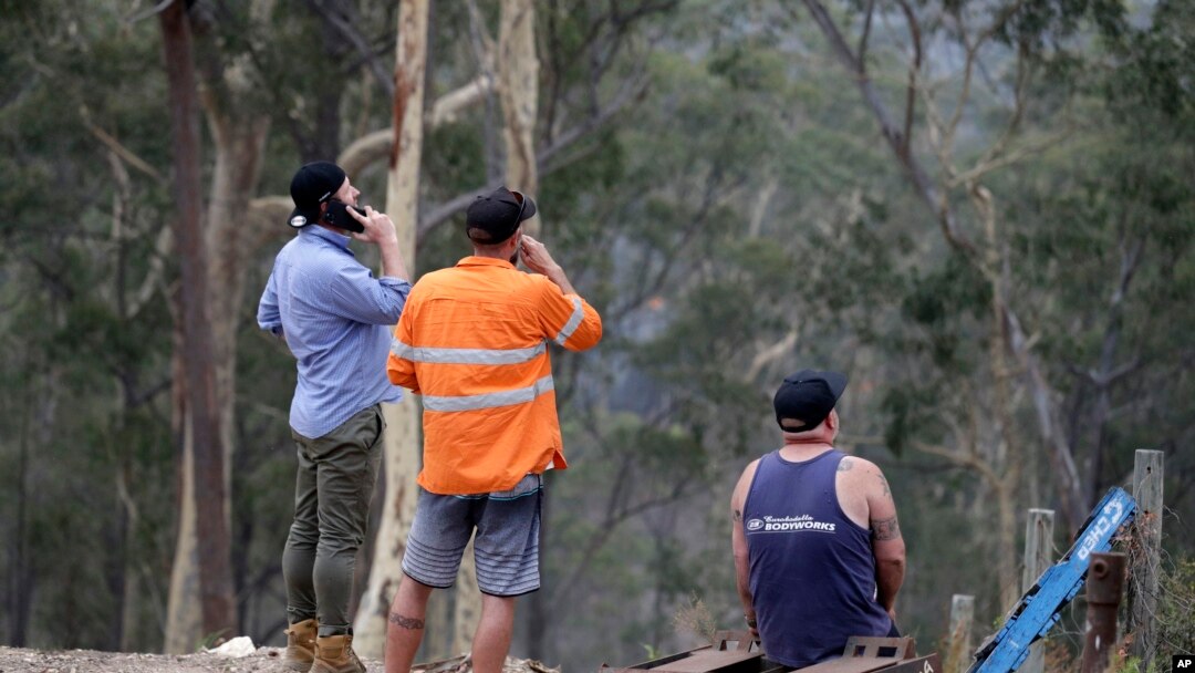 Residents on edge of Batemans Bay, Australia, relax after a fire threat near their homes eased Saturday, Jan. 4, 2020.