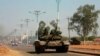 A military tank patrols along one of the main roads in the South Sudanese capital Juba, Dec. 16, 2013. The South Sudanese president declared a curfew in the capital Juba on Monday after clashes overnight between rival factions of soldiers.