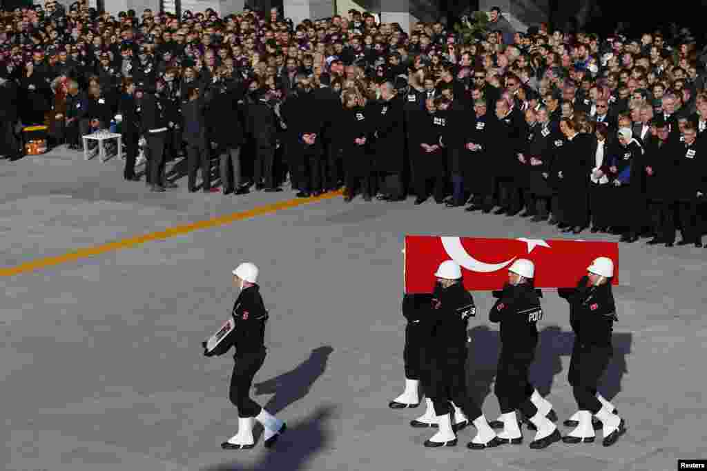Turkish police officers carry a coffin of a fellow officer during a ceremony for police officers killed in Saturday's blasts in Istanbul, Dec. 11, 2016.