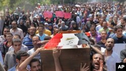 Pendukung Morsi (16/8) mengusung peti mati salah seorang demonstran yang tewas dalam penghancuran kamp-kamp demonstran oleh pemerintah Mesir hari Rabu. 