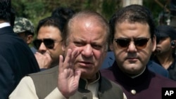 PM Pakistan saat itu, Nawaz Sharif, tengah, meninggalkan lokasi Tim Gabungan Investigasi bersama putranya Hussain Nawaz, kanan, di Islamabad, Pakistan, Kamis, 15 Juni 2017 (foto: AP Photo/B.K. Bangash)