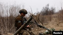 격전지 바흐무트 인근 전투에 참가한 우크라이나군 제80 공중강습여단 병사가 지난 16일 러시아군 진영 방향으로 사격 명령을 기다리고 있다. (자료사진)