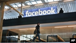 FILE - Facebook logo is displayed in a start-up companies gathering in Paris, France, Jan. 17, 2017.