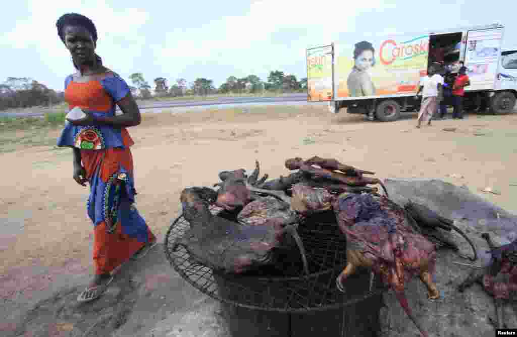Une femme passe devant la viande de brousse séchée près d'une route de Yamoussoukro, Côte d’Ivoire; le 29 mars 2014. REUTERS / Thierry Gouégnon.