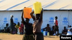 Des femmes ayant fui le Soudan du Sud, a la recherche du liquide précieux, après leur arrive au camp de réfugiés de Bidi Bidi, en Ouganda, le 7 décembre 2016.