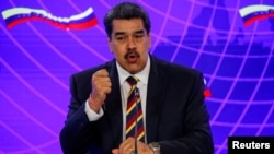 El presidente de Venezuela, Nicolás Maduro, habla junto al viceprimer ministro ruso, Yury Borisov, después de firmar documentos de un acuerdo bilateral en el Palacio de Miraflores durante su visita a Caracas, el 16 de febrero de 2022. 