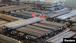 Workers check steel products at a factory in Dalian, Liaoning Province, China, March 30, 2016. 